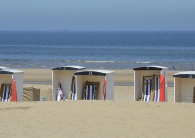 badhuisjes en strandstoelen met zicht op zee