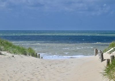 mooi-uitzicht-strandopgang-met-palen-en-duingras-naar-zee-en-strand-in-katwijk-aan-zee