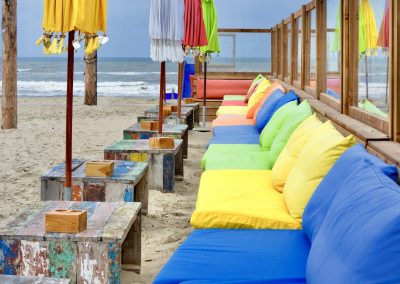 strandpaviljoen met gekleurde stoelen en parasols