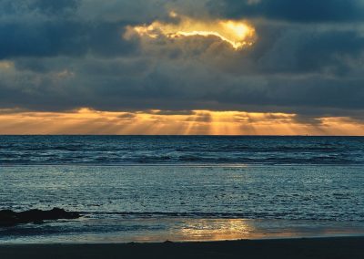 zonneharp aan de horizon bij zonsondergangmet weerspiegeld water in katwijk aan zee